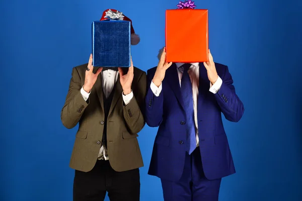 Empresarios esconden caras detrás de cajas de regalo rojas y azules — Foto de Stock
