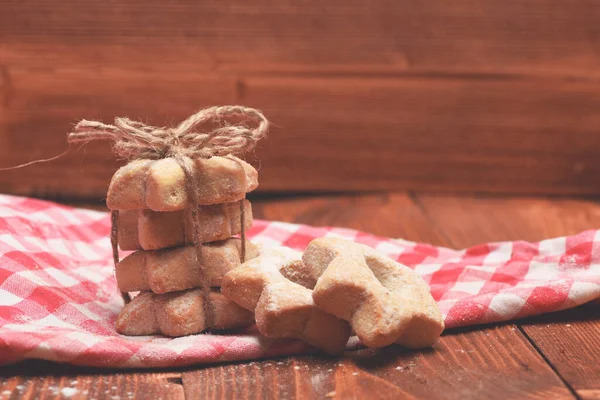 Biscoitos em forma de estrela amarrados em pirâmide em pano vermelho. — Fotografia de Stock