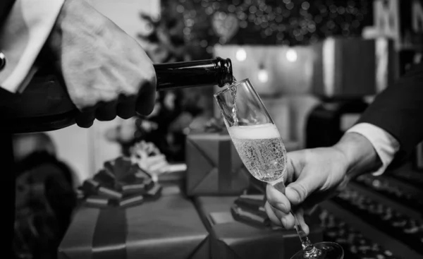 Último minuto antes de año nuevo. Beba champán o vino espumoso. Celebra el año nuevo con champán. Concepto de salud. Manos vertiendo champán en el fondo de decoraciones de Navidad de cristal elegante —  Fotos de Stock