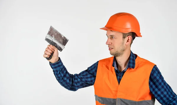 Carpenter ready to work. building tool repair equipment. young worker is engineer assistant. repairman in uniform. man use spatula tool. real construction worker in helmet — Stock Photo, Image