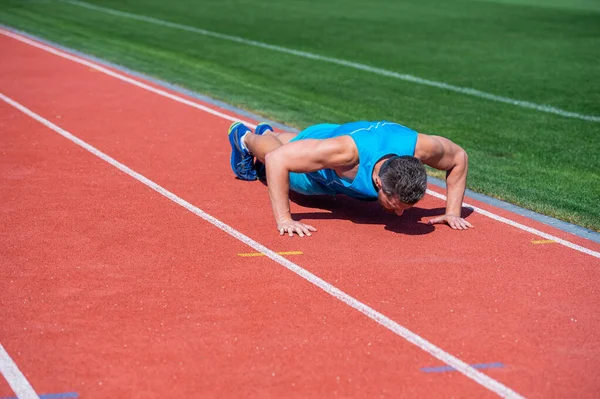 Musculoso hombre de pie en la tabla haciendo empujar hacia arriba en el entrenamiento deportivo, el éxito — Foto de Stock