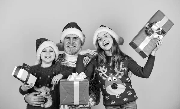 Tijd voor cadeautjes. Gelukkige familie viert Kerstmis. kleine meisjes wisselen geschenken uit met vader. Papa houdt van dochters. Een bebaarde kerstman met kinderen. gebreide mode voor de winter. Nieuwjaar winkelen — Stockfoto