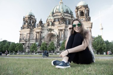 Berlin Katedrali 'nin önünde oturuyor.