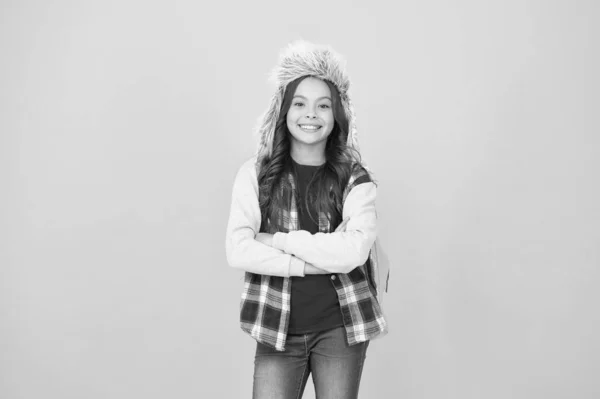 Děvčátko nosí klobouk s klapkami na uši. Zimní události ve škole. Zimní zábava a aktivity. Bezstarostná školačka. Zimní dovolená. Přihlaste se na mezinárodní výměnné a terénní školní programy — Stock fotografie