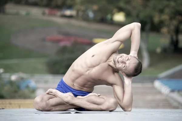 Atletický muž dělá jógu asanas v parku — Stock fotografie
