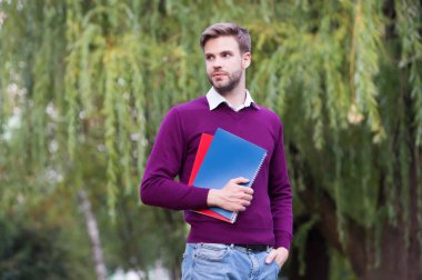 Ders çalışma zamanı. Öğretmenim. Adam defteri tutuyor. Yakışıklı adam parkta çalışma kitaplarıyla yürüyor. Modern yaşam eğitimi. Öğrenci kitaptan bilgi alıyor. Yakışıklı, tıraşsız öğrenci dışarıda ders çalışmaya gidiyor.