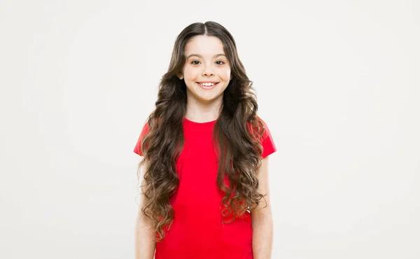 Salão de cabeleireiro. cuidados com a pele e cabelo natural. felicidade infantil. menina feliz com cabelo encaracolado longo. moda e beleza. Criança hipster. Uma menina a sorrir. cabeleireiro para pequeno fashionista — Fotografia de Stock