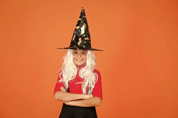 C'est parfait. Un tour ou un régal. cheveux gris charme surnaturel. Enfant enchanteur fond orange. Joyeux Halloween. fantasme magique. fille souriante fête d'Halloween. mystérieuse sorcière. petit chapeau de sorcière enfant — Photo