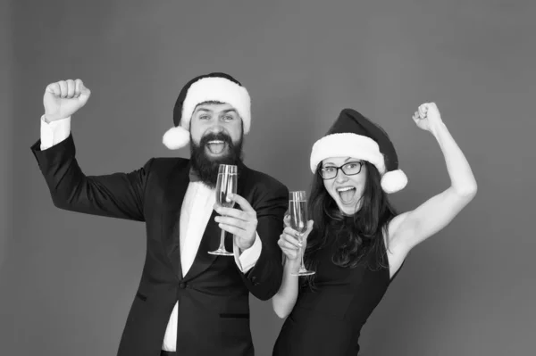 Vrolijke mensen. Vrolijk kerstfeest. Kantoorfeestje. Verliefd stel op het feest. Gelukkig nieuwjaar. Baard man in smoking en meisje elegante jurk drinken mousserende wijn en dansen rode achtergrond. Winterfeest — Stockfoto