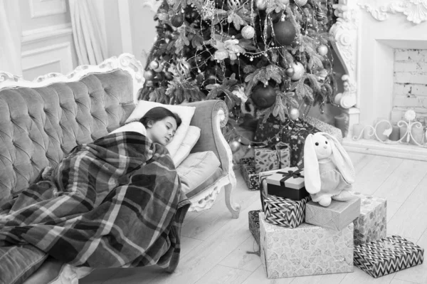 Julafton. Gott nytt år. Liten flicka sova soffa nära julgran klassiska interiör. Familjesemester. Julgran och julklappar. Drömmer om gåvor. Tro på mirakel. Magiskt ögonblick — Stockfoto