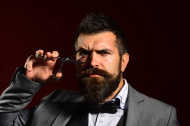 Uzun sakallı adam çelik makas tutuyor..