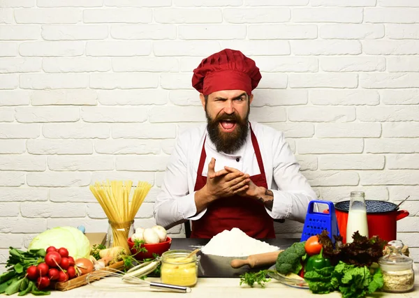 Man med skägg gnuggar händerna på vit tegelvägg bakgrund. — Stockfoto