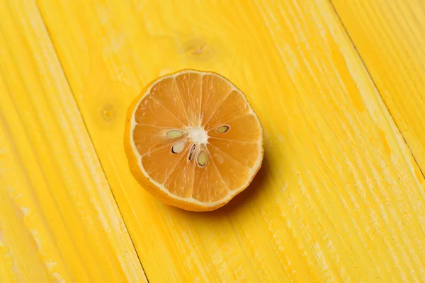 노란 나무 배경에 있는 레몬 절반 — 스톡 사진