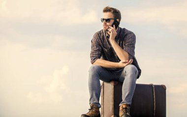 Bir bilet ayırt. Gezgin, taksi bekle. Çekil şuradan. Seksi adam gökyüzü arka planı telefonda konuşuyor. Maço turist rahat tur çantası. Erkek modası. Çok modaya uygun görünüyorsun. Gözlüklü iş adamı. iş gezisi