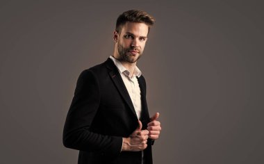Yakışıklı adam resmi takım elbise giyer. Gömlek ve ceket giyen kendine güvenen bir iş adamı. patron erkek. Gri arka planda seksi CEO. Modern ofis hayatı. Karizmatik iş sahibi. şık bir emlakçı.