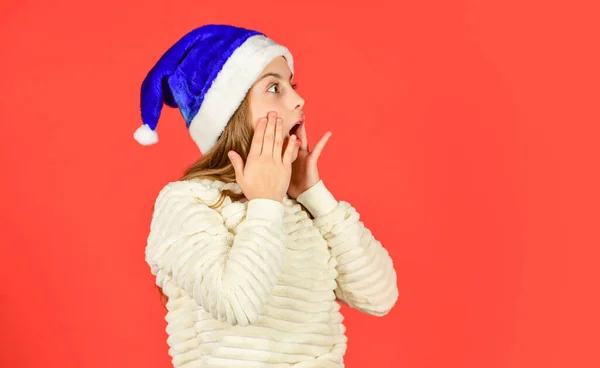 Menina pequena santa claus chapéu fundo vermelho. espaço de cópia. prepare-se para a festa de ano novo. Natal feriado favorito. estação alegre de inverno. humor de Natal. O pequeno Pai Natal espera a venda. Uau! — Fotografia de Stock