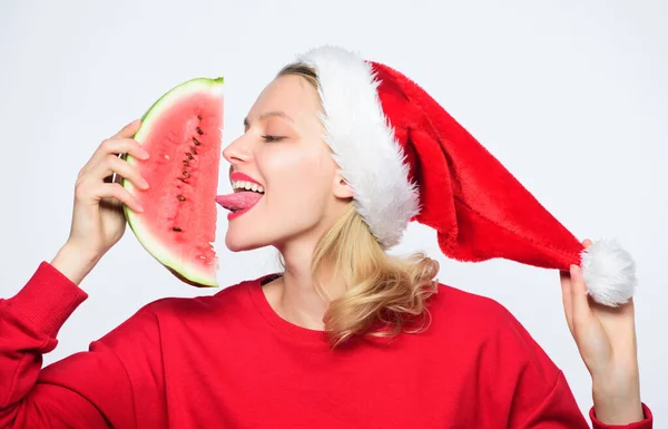 漫长的夏天圣诞节假期和度假胜地。美味的圣诞节概念。女人的桑塔帽子拿着薄片西瓜.圣诞节夏季目的地。圣诞女孩吃西瓜 — 图库照片
