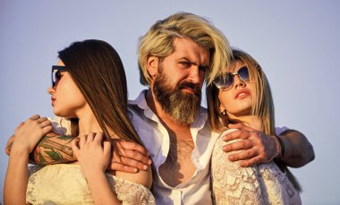 Harika görünüyorsun. Yaz gün batımında rahatla. Güzellik ve moda. Moda insanları yaz kıyafetiyle sıradan görünürler. Bir grup insan. Aşk ve arkadaşlık kavramı. Vahşi adam iki seksi kadını kucaklıyor. Genç ve özgür