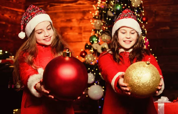 Flicksystrar tomtedräkter. Barn vackra vänner möter jul semester. Familjen firar jul. Samhörighetskoncept. Festlig stämning på juldagen. Dekorera julgran tillsammans — Stockfoto