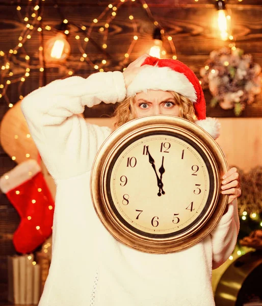 Time for winter party. Woman Santa hat hold vintage clock. Time to celebrate. Merry christmas. Time for miracles. Few minutes left. New year countdown. Unexpectedly soon. Midnight concept. Make wish