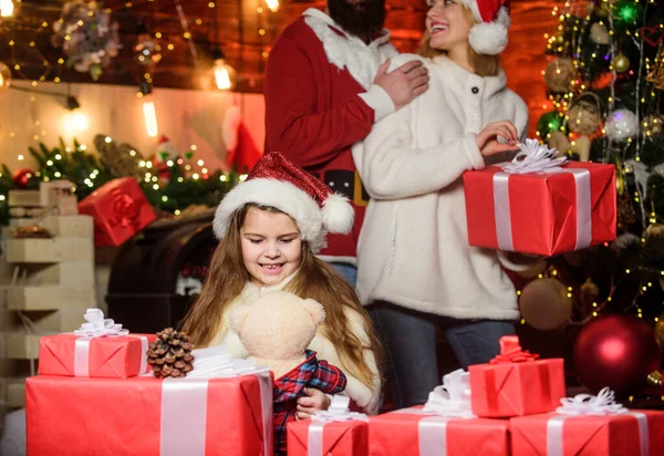 Weihnachtsstimmung. kleines Kind und Eltern mit Weihnachtsmütze. Glückliche Familie feiern das neue Jahr. Frohe Weihnachten. Vater und Mutter lieben ihre Tochter. Weihnachtsgeschenkboxen. Offene Gegenwart. Winterurlaub. Einkaufsgutscheine — Stockfoto