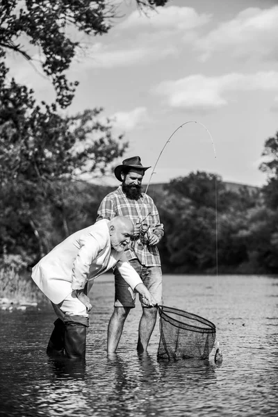 Des amis attrapant du poisson. Loisirs et loisirs. Attraper des poissons avec l'âme soeur. Homme barbu et pêche hipster brutale. Jour de famille. Équipe de pêche. Tranquillité et tranquillité. Des poissons d'eau douce. Journée active — Photo