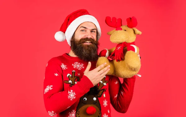 Un hombre brutal sostiene un juguete de renos. compras en línea de Navidad. hipster barbudo en jersey de Navidad. fiesta de invierno. chico maduro celebrar el año nuevo. hombre con barba en sombrero de Santa Claus —  Fotos de Stock