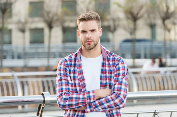 Mükemmel tarzı. Modern yaşam konsepti. Öğrenci yürüyüşü. Yakışıklı genç adam kareli gömlek giyiyor. Açık havada poz veren sıradan erkek manken. Tıraşsız, kıllı, şehir tarzı bir adam.