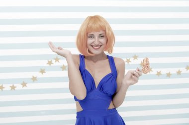 Oyuncu modunda çılgın bir kız. Lolipopu olan havalı bir kız. Seksi bir kadın. Turuncu saçlı moda kızı eğleniyor. Elinde lolipop olan mutlu poster modeli. Hoş görünüş. Deliriyorum. Çok eğlenceli. İyi eğlenceler.