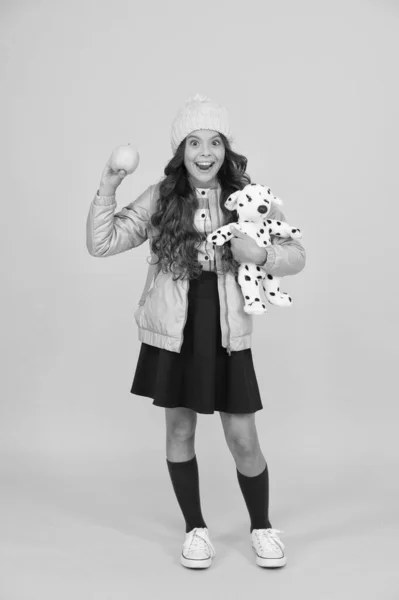 Un día normal en la escuela. Fondo amarillo niño feliz. Ropa abrigada para la estación fría. La chica de moda parece hipster. Sombrero de invierno para niña. Moda colegiala usar chaqueta falda y calcetines largos — Foto de Stock