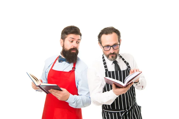 Einige Probleme. Hauswirtschaftliche Aufgaben. Kochrezepte. Wie man kocht. Männer bärtige Hipster-Kochschürze lesen Bücher über Kulinarik. Keine Ahnung, wie man Essen zubereitet. Kulinarisches Buchkonzept. Männer im Haushalt — Stockfoto