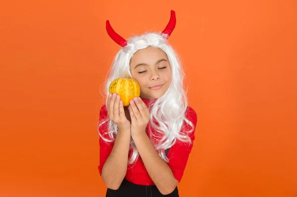 Lost in thoughts. jack o lantern. happy halloween. kid wear devil horns. child with pumpkin. teen girl wear long curly white hair wig for party celebration. autumn season holiday. childhood leisure — Stock Photo, Image