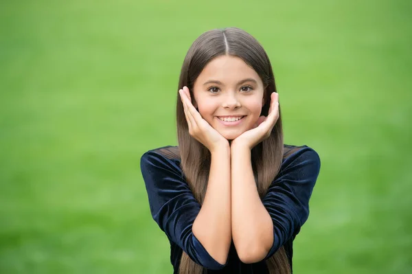 Laat je huid glanzen. Gelukkig meisje lacht groen gras. Huidgezondheid. Pediatrische dermatologie. Natuurlijke huidverzorging. Schoonheidssalon. Raak je gezicht aan als je handen schoon zijn. — Stockfoto