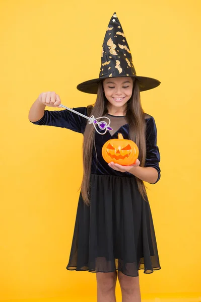 Halloween tini lány boszorkány kalap tartsa mágikus pálca és tök jack o lámpás boszorkányság, boldog halloween — Stock Fotó