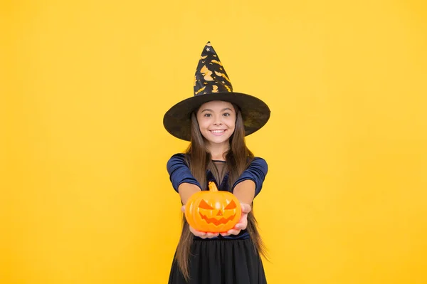 Šťastný dítě nosit čarodějnice klobouk držení dýně vytvořit jack o lucerna na halloween, halloween jack o lucerna — Stock fotografie