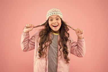 Örülmüş aksesuar. Küçük kız kış şapkası. Neşeli çocuk pembe arka planı. Sonbahar tarzı. Mutlu çocukluk. Çocuk modası ve alışveriş. Moda kızı komik görünümü. Soğuk mevsim için sıcak kıyafetler