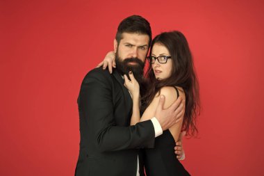 Biz farklıyız ama birbirimizi seviyoruz. Kırmızı arka planda aşık bir çift. Sakallı adam seksi kadına sarıldı. Aşk randevusu ve randevu. Aşk ve romantizm. Romantik bir ilişki. Sevgililer Günü