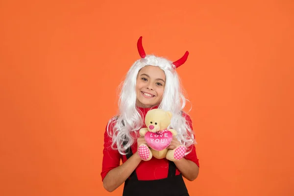 Щаслива відьма дитина з плюшевим ведмедем іграшка носить костюм роги дому на вечірці на Хеллоуїн, подарунок на Хеллоуїн — стокове фото