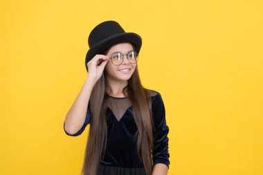 Gözlüklerime aşık oluyorum. Mutlu çocuk sarı arka plan gözlüğü takıyor. Moda gözlüğü. Childs görüş düzeltmesi. Düzeltici lens. Optik göz merceği. Pediatrik göz bilimi optiği. Güzel görünüş