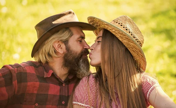 Sentimientos verdaderos. Disfrutando de la vida. Amor y armonía. Vaquero barbudo con sombrero besando a su adorable novia. Pareja enamorada. Un beso romántico. Felices propietarios de ranchos. Casado y feliz. Gente rústica enamorada — Foto de Stock