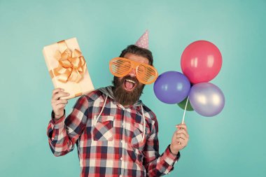 Alışverişe gidiyorum. Balonla gülümseyen hippi. Mutlu bir partiyi kutluyoruz. Parti elemanları ve tatil eşyaları. Çok renkli eğlence. Emeklilik için en iyi parti. Sakallı neşeli adam, hediyemi tut.