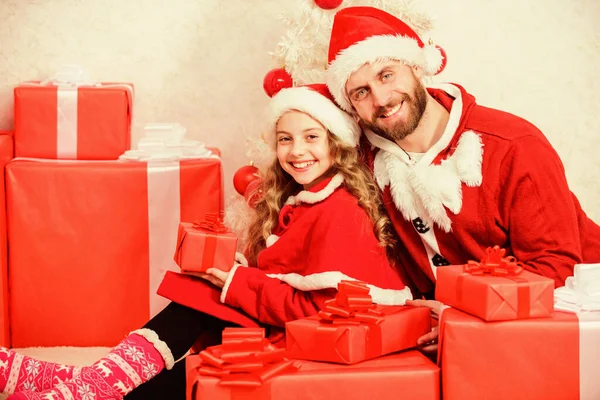 Feliz infancia. Vacaciones familiares de Navidad. Haz que tus vacaciones infantiles sean especiales este año. Concepto de Papá Noel. Regalo de Navidad para niño. papá en traje de santa dar regalo a hija lindo niño — Foto de Stock