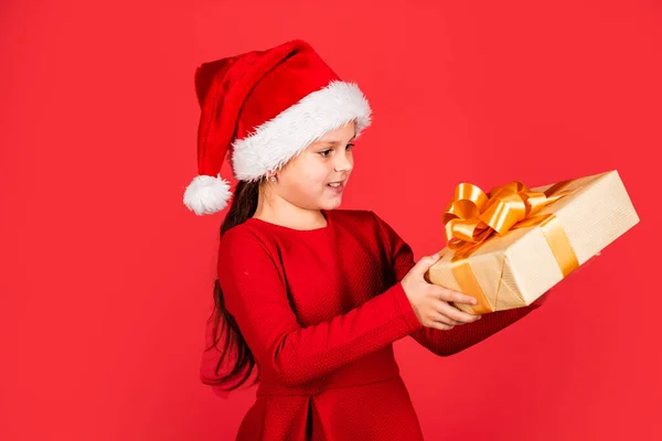 Holiday atmosphere. cheerful kid hold new year present. gift box and parcel delivery. merry christmas. ready for xmas party. happy winter holidays. greeting and congratulation. small santa helper