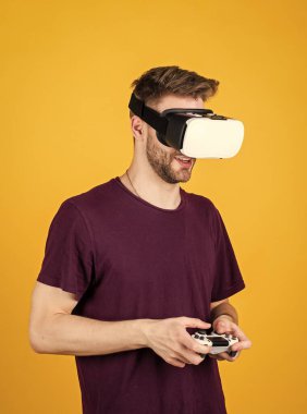 Modern teknolojiler. Adam kablosuz internet gözlüğü takıyor. Adam video oyunu oynuyor. Konsollu oyun oyuncusu. VR kulaklıklı bir erkek. Mutlu oyuncular modern teknolojiyi kullanır. Dijital gelecek ve yenilik. Görsel gerçeklik