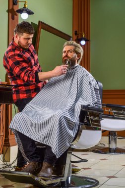 Sakallı ve şık. Tıraş. Berber dükkanındaki kuaför. Kuaförde hippi tıraşlı bir adam. Sakal ve bıyık. Berber dükkanında profesyonel kuaför. Şık erkek sakalı portresi