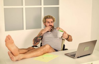 Evde çalışan yalınayak adam. Evde dizüstü bilgisayarda çalışan bir adam. Rahat bir iş yeri. Geliştirici iş bilgisayarı. Sosyal ağlar iletişimi. Sosyal uzaklık. Rahatla biraz. Ev en iyi ofistir.