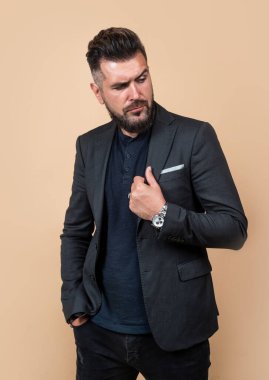 Tıraşsız stil sahibi adamın saçları bakımlı. Erkek güzellik ve moda. Sakallı, olgun bir hippi. İş yeri modası. Bıyıklı, vahşi, beyaz bir hippi. Zarif iş adamı resmi takım elbise giyer.