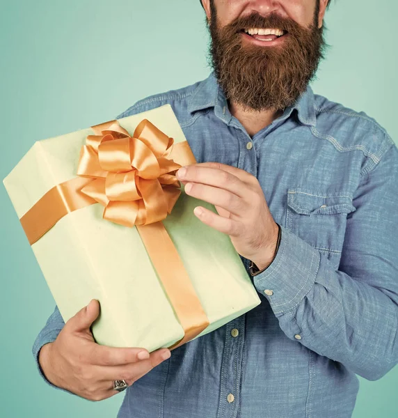 bearded man gift holiday decoration. businessman holding big gift box. gift to colleague at work. surprised man unpacking. the package delivery. human emotion and facial expression