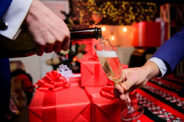 Um conceito de saúde. Mãos derramando champanhe em vidro elegante fundo decorações de Natal. Último minuto antes do ano novo. Beba champanhe ou vinho espumante. Celebrar o ano novo com champanhe — Fotografia de Stock