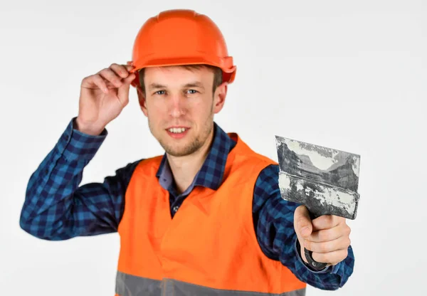 Reparateur in Uniform. Mann benutzt Spachtelwerkzeug. echter Bauarbeiter mit Helm. Tischler bereit zur Arbeit. Werkzeugbau-Reparaturausrüstung. junger Arbeiter ist Ingenieur-Assistent. Bauingenieur Architekt — Stockfoto